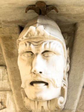 Trieste, İtalya - 14 Ekim 2025: Tarihi savaşçı yüzü heykeli, duvara monte edilmiş ayrıntılı taş çalışması, sanatsal ve kültürel önemi yansıtıyor