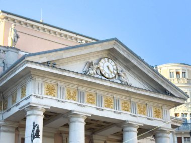 Trieste, İtalya - 14 Ekim 2025: Tarihi bina, parlak mavi gökyüzüne karşı klasik mimariyi vurgulayan karmaşık saat ve heykeller içeriyor
