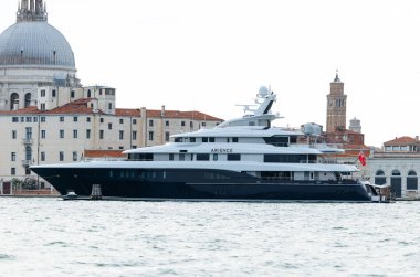 Venedik, İtalya - 23 Haziran 2025: Lüks yat Yükseliş Venedik 'te demirlemiş, karmaşık tasarımı ve tarihi yapıların ve sakin suların güzel arkaplanı vurgulanmıştır.