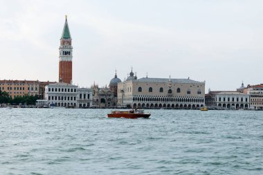 Venedik, İtalya - 23 Haziran 2025: İkonik Venedik Büyük Kanal boyunca Campanile ve sakin sularda yüzen bir tekneyle tarihi mimari sergiliyor