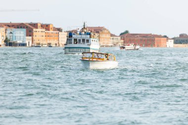 Venedik, İtalya - 23 Haziran 2025: Venedik 'te canlı binalar ve İtalyan kıyı kültürünün özü ile çevrili küçük bir tekne suda hareket ediyor.