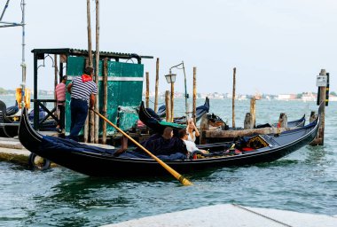 Venedik, İtalya - 23 Haziran 2025: Venedik 'te gondol gezisi gondolcuları ve turistleri canlı çevresiyle birlikte manzaralı Büyük Kanal' ın keyfini çıkarıyor