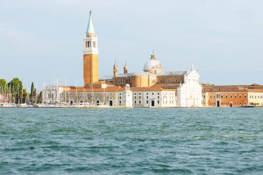 Venedik, İtalya - 23 Haziran 2025: Venedik 'teki güzel San Giorgio Maggiore Adası sakin sular ve yelkenlilerle çevrili bir çan kulesi ve kilise barındırır.