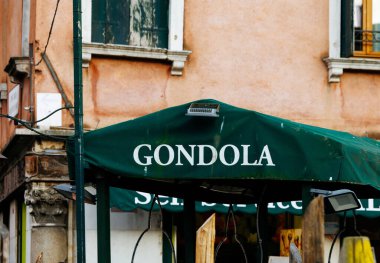 Venedik, İtalya - 23 Haziran 2025: Venedik, İtalya 'da Gondol tabelasıyla kaplı yeşil tente, şehrin zengin kültürünü ve pitoresk kanallarını yansıtıyor.