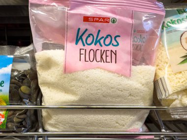 Villach, Avusturya - 23 Ekim 2025: SPAR hindistan cevizi gevreği paketi süpermarket rafında sergileniyor, canlı renkler vurgulanıyor ve mutfak kullanımı için cazip tasarım