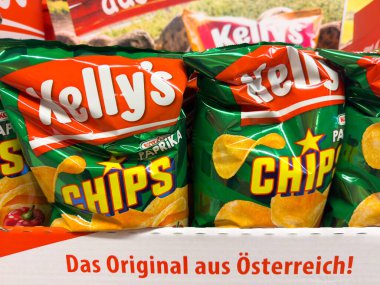 Villach, Avusturya - 23 Ekim 2025: Kelly 'nin cips ambalajı parlak renkler ve göz alıcı tasarım içeren bir rafta sergilenen kırmızı biber aromalı.