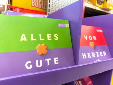 Villach, Avusturya - 23 Ekim 2025: Özel durumlar için neşeli mesajlar ve canlı tasarımlar içeren renkli tebrik kartları bir rafta düzenlenir