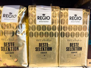 Villach, Avusturya - 23 Ekim 2025: Rafta Regio Rosterei kahve poşetleri, zarif altın ve siyah ambalaj tasarımı ile% 100 Arabika fasulyesi vurgulanıyor