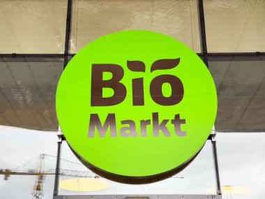 Villach, Avusturya - 23 Ekim 2025: BiyoMarkt işareti canlı yeşil renkli ve kalın harfli, çağdaş bir ortamda organik ve sürdürülebilir alışveriş seçeneklerini vurguluyor