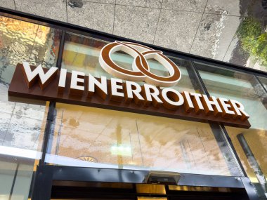 Villach, Avusturya - 23 Ekim 2025: Wienerroither pastane tabelası, yoldan geçenler için mağaza önü atmosferini artıran klasik bir simit logosuna sahiptir.