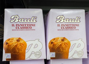 Tarvisio, İtalya - 17 Ekim 2025: Bauli klasik panettone kutuları bir süpermarket rafına dizilir, şenlik tasarımı ve lezzetli tatlar vurgulanır