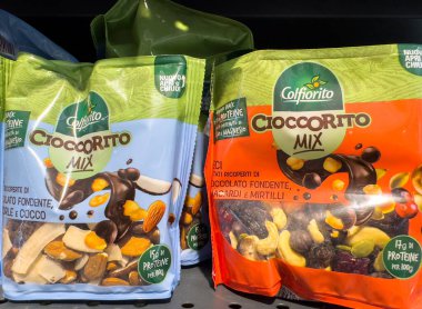 Tarvisio, İtalya - 17 Ekim 2025: Colfiorito Cioccoritto Karışık abur cubur paketleri, renkli tasarımlar ve sağlıklı seçenekleri ön plana çıkaran süpermarket raflarında çikolata kaplı fındık ve meyveler sergiliyor