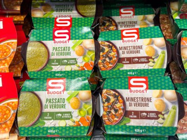 Tarvisio, İtalya - 17 Ekim 2025: Bütçe sebze çorba paketleri süpermarket raflarında renklendirici markalı sebze püresi ve sebze püresinin altını çizerek düzgünce düzenlenmiştir