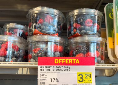 Tarvisio, İtalya - 17 Ekim 2025: Süpermarket raflarında sergilenen taze karışık orman meyveleriyle dolu temiz kaplar, canlı renkler ve sağlıklı atıştırmalık seçenekleri vurguluyor
