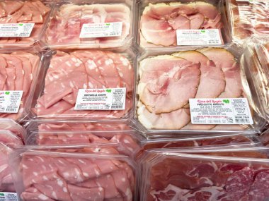 Tarvisio, İtalya - 17 Ekim 2025: Bir bakkalda paketlenmiş et, farklı türde jambon ve salam içeren yemek ve yemek fikirleri