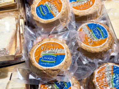 Tarvisio, İtalya - 17 Ekim 2025: Açık ambalajda sanatsal ricotta peyniri tekerlekleri, kaliteli süt ürünlerini ön plana çıkaran yerel bir pazarda güzelce düzenlenmiştir