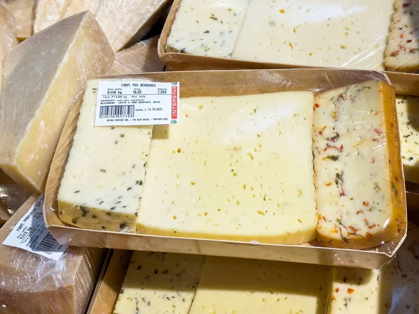 Tarvisio, İtalya - 17 Ekim 2025: Bir şarküteri tezgahında çeşitli gurme peynirleri, gıda aşıkları için dokuları ve tatları vurguluyor