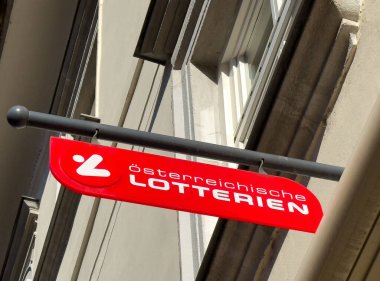 Villach, Avusturya - 29 Ekim 2025: Osterreichische Lotterien tabelası bina cephesinde, koyu kırmızı renkte ve piyango hizmetleri için açık harflerle gösteriliyor