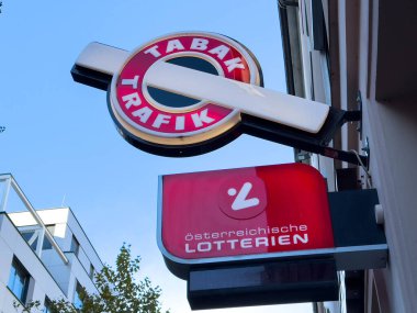 Villach, Avusturya - 29 Ekim 2025: Avusturya 'nın Viyana kentinde TABAK TRAFIK tabelası, açık bir gökyüzünde yerel ticaret ve kültürü ön plana çıkaran koyu renk ve markalaşma özelliklerine sahiptir.