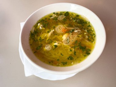 Bir kase tavuklu erişte çorbası, sebzeli ve taze otlu..