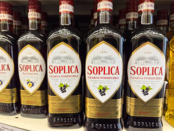 Klagenfurt, Avusturya - 29 Ekim 2025: Soplica kuşüzümü likörü şişeleri bir mağaza rafında düzgünce düzenlenmiş, çekici tasarımlarını ve markalarını ön plana çıkarıyor