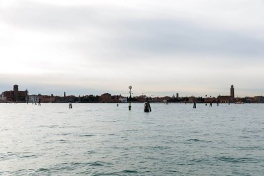 Murano, İtalya - 21 Kasım 2024: Huzurlu sulara ve sakin çevreye yansıyan ikonik Venedik binalarına sahip Murano Adası 'nın güzel manzarası