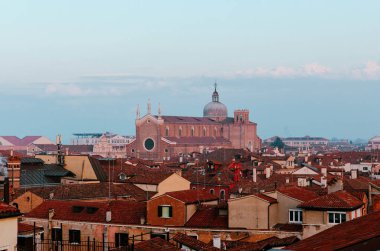 Venedik, İtalya - 20 Kasım 2024: Venedik 'in manzaralı çatısı tarihi mimari ve terasotta çatılarını sakin bir gökyüzüne karşı gözler önüne serdi