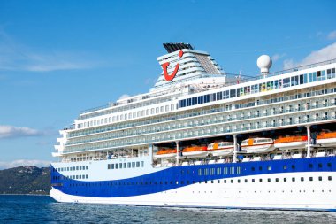 Trieste, İtalya - 14 Ekim 2025: TUI yolcu gemisi berrak bir gökyüzü ile sakin sularda demirlemiş, çarpıcı tasarımı ve davetkar atmosferi vurguluyor