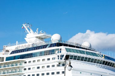 Trieste, İtalya - 14 Ekim 2025: Lüks yolcu gemisi, üst güverte ve seyrüsefer özelliklerini vurgulayan canlı mavi gökyüzüne karşı parlak bir tasarım sergiliyor