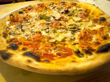 Mantarlı, enginarlı ve kıtır kıtır jambonlu lezzetli İtalyan pizzası..