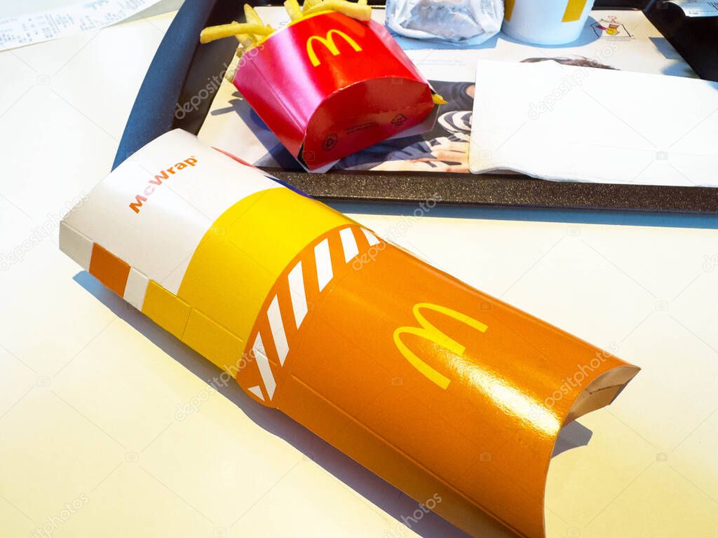 Villach, Austria - November 10, 2025: McDonald's McWrap placed on a tray alongside fries and drinks, highlighting fast food culture and vibrant packaging