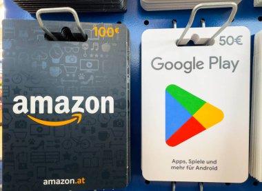 Villach, Avusturya - 12 Kasım 2025: Amazon ve Google Play hediye kartları, kullanıcılar için dijital ödeme seçeneklerini ön plana çıkaran mavi bir rafta sergilenmektedir
