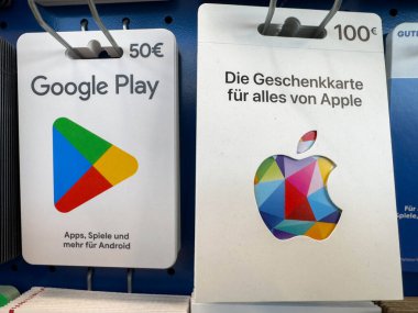 Villach, Avusturya - 12 Kasım 2025: Google Play ve Apple hediye kartları renkli logolar ve açık fiyatlandırmayla perakende rafında belirgin bir şekilde sergilenmektedir