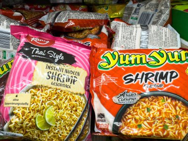 Villach, Avusturya - 12 Kasım 2025: Yum Yum ve Kani markalarından karides aromalı anlık erişte paketleri rengarenk tasarımlarla bakkal rafına dizilmiş