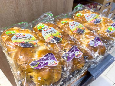 Villach, Avusturya - 12 Kasım 2025: Kuru üzümlü ekmekler düzgünce paketlenir ve bir market rafında sergilenir, çekici etiketleri ve dokuları vurgulanır