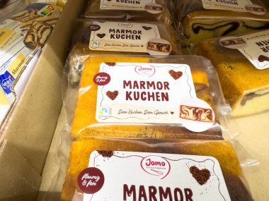 Villach, Avusturya - 12 Kasım 2025: Jomo Marmorkuchen bir mağaza rafına güzelce paketlenmiş, büyüleyici mermer pasta tasarımı ve tatlarını vurguluyor