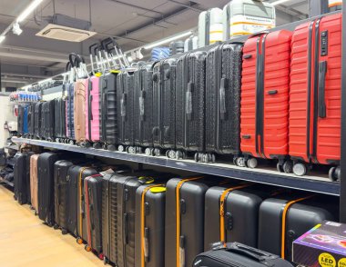 Villach, Avusturya - 25 Kasım 2025: Perakende mağazası, seyahat gereksinimlerini ve çağdaş tasarımı vurgulayarak raflarda düzenli olarak çeşitli renkli bavullar barındırıyor