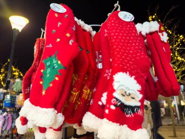 Villach, Avusturya - 02 Aralık 2025: Şenlik desenli parlak Noel eldivenleri bir tatil pazarında sergilenerek sezonun özünü yakalıyor