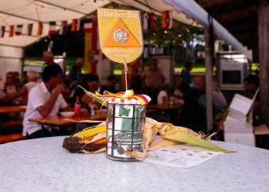 Rosegg, Avusturya - 17 Eylül 2023: Açık hava etkinlik masasında dekoratif mısır ve renkli bir afiş sergilenerek, toplumsal kutlama ortamının şenlikli havası artırıldı