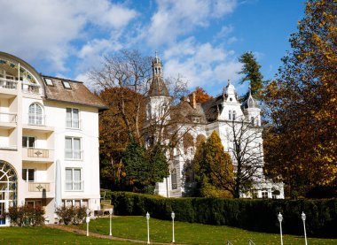 Büyüleyici Avrupai mimari: Kulesi olan tarihi bina, konutlara komşu, sonbahar manzarası.