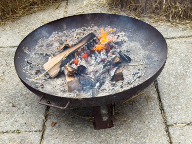 Taştan verandasında yanan odunları olan taşralı bir ateş çukuru..