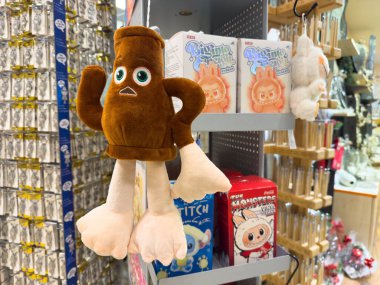 Villach, Avusturya - 10 Aralık 2025: Eğlenceli ürünlerle dolu canlı bir mağazada kahverengi gövdeli ve beyaz ayaklı çizgi film pelüş oyuncağı