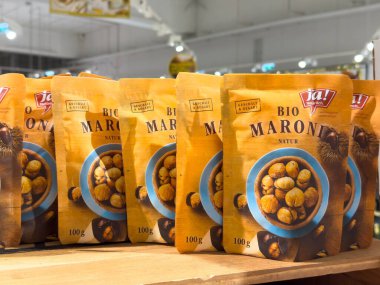 Villach, Avusturya - 10 Aralık 2025: Ja 'dan organik kestane ürünleri! Marketteki ahşap bir rafta, sağlıklı abur cubur seçeneklerini vurguluyorlar.