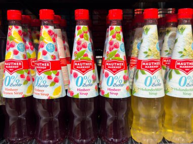 Villach, Avusturya - 10 Aralık 2025: Ahududu ve mürver çiçeği aromalı Mautner Markhof şurupları bir süpermarket rafında renklendirici ambalaj ve cazip tasarımı vurguluyor