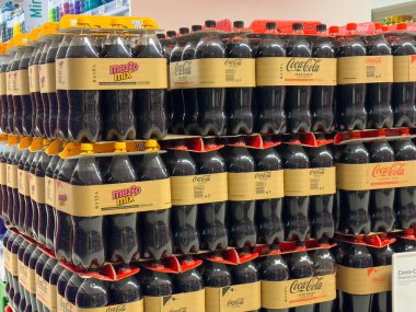 Villach, Avusturya - 10 Aralık 2025: Bir süpermarkette Coca-Cola ve Mezzo Mix şişelerinin gösterimi, renkli ambalajlarda popüler meşrubatları vurguluyor