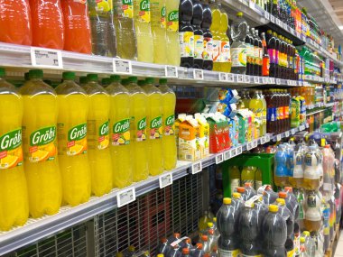 Villach, Avusturya - 10 Aralık 2025: Grobi marka şişelerin raflarda yer aldığı canlı meşrubat, meyve suyu ve aromalı sularla dolu meşrubat reyonu