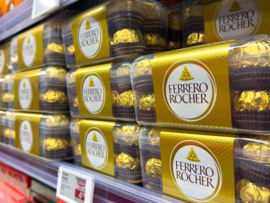 Villach, Avusturya - 10 Aralık 2025: Ferrero Rocher çikolata kutuları bir süpermarket rafına yerleştirilmiş, zarif tasarımları ve hediye için cazibeleri vurgulanıyor