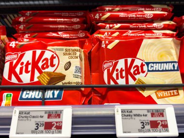 Villach, Avusturya - 10 Aralık 2025: Kit Kat Chunky çikolataları klasik ve beyaz aromalı süpermarket raflarında temiz fiyatlandırma etiketleriyle düzgünce düzenleniyor