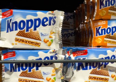 Villach, Avusturya - 10 Aralık 2025: Knoppers sütlü gofretler, çıtır çıtır tabakalarını ve çekici ambalajlarını ön plana çıkaran bir mağaza rafına güzelce yerleştirilmiştir