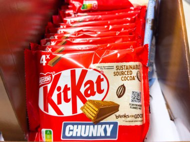Villach, Avusturya - 10 Aralık 2025: KitKat Chunky çikolataları çekici tasarımlarını ve sürdürülebilirlik mesajlarını vurgulayarak perakende satış kutusuna yerleştirilmiştir